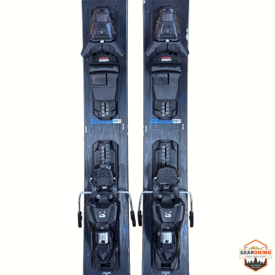 Gearonimo Sports K2 Mindbender 99ti skis in black with mounted Salomon M11 GripWalk bindings, top-down view.