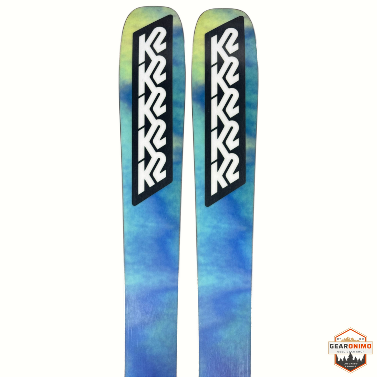 Gearonimo Sports K2 Mindbender 99ti skis with blue and yellow tie-dye pattern and Salomon M11 bindings