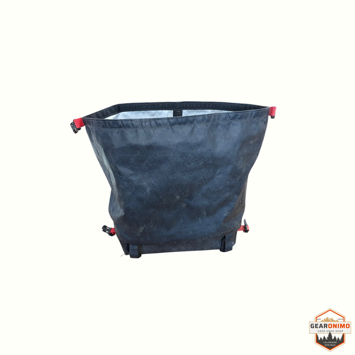 Gearonimo Sports Revelate Designs black waterproof bike bag with roll-top closure and red strap accents