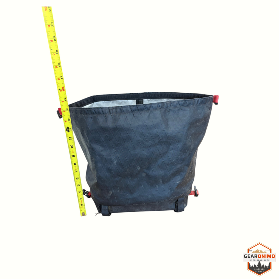 Gearonimo Sports black Revelate Designs bike bag with a yellow measuring tape showing height on a white background
