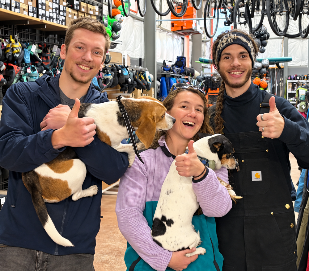 The Gearonimo team smiling with their two dogs inside the shop
