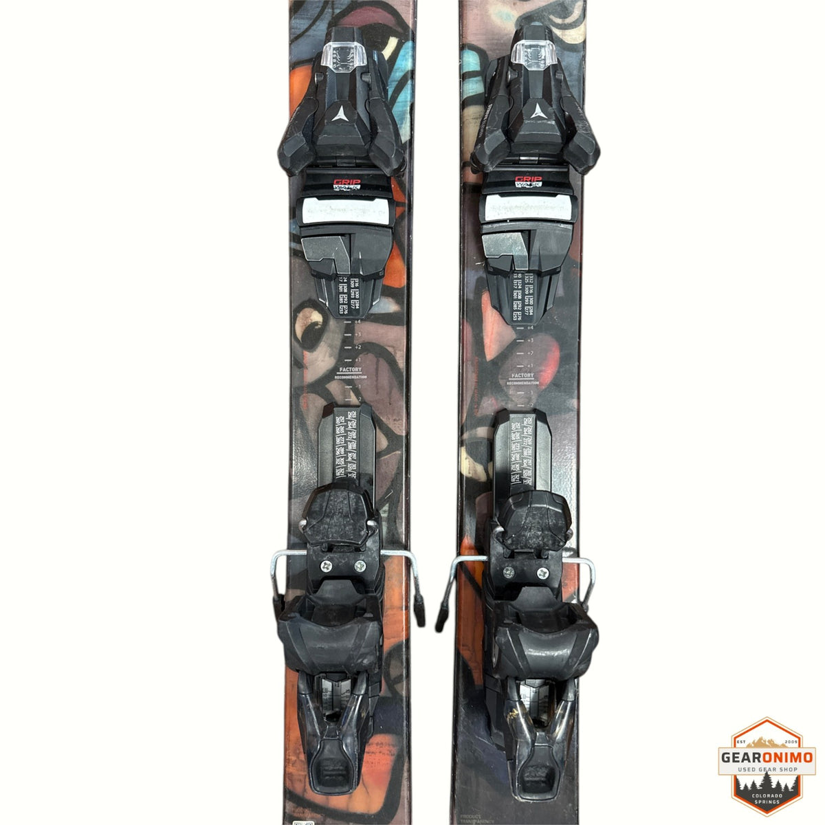Gearonimo Sports Atomic Bent 100 skis with black bindings, featuring artistic graphic topsheets on a textured surface.