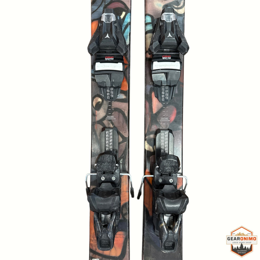 Gearonimo Sports Atomic Bent 100 skis with black bindings, featuring artistic graphic topsheets on a textured surface.