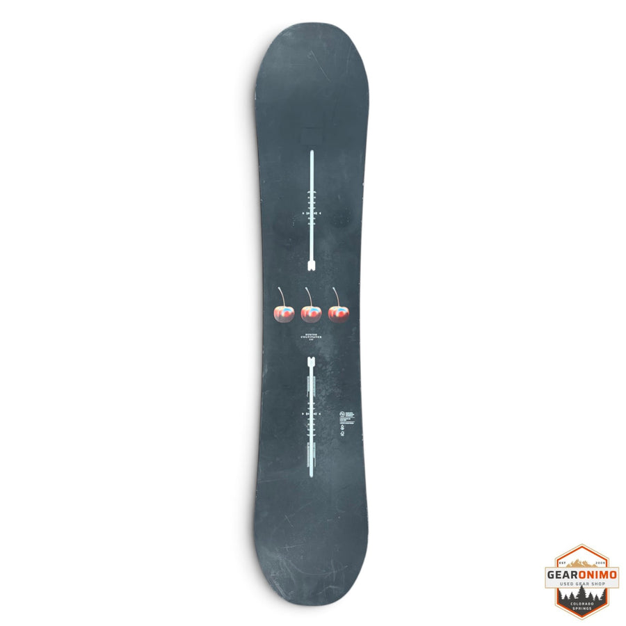 Gearonimo Sports Burton Cultivator snowboard in black with a central cherry graphic on a red concrete floor
