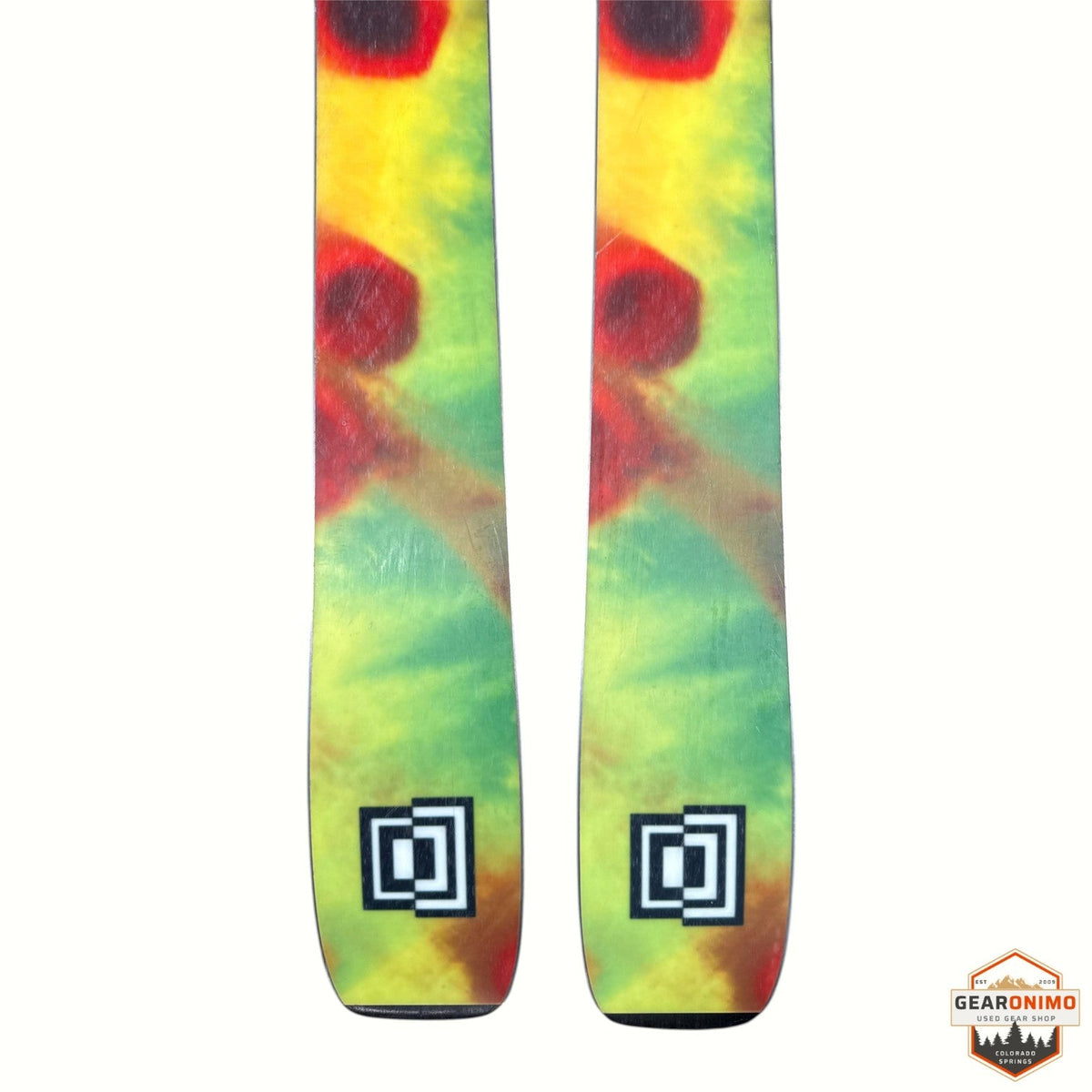Gearonimo Sports K2 MindBender 89ti skis featuring a vibrant yellow, green, and red tie-dye pattern on the tips