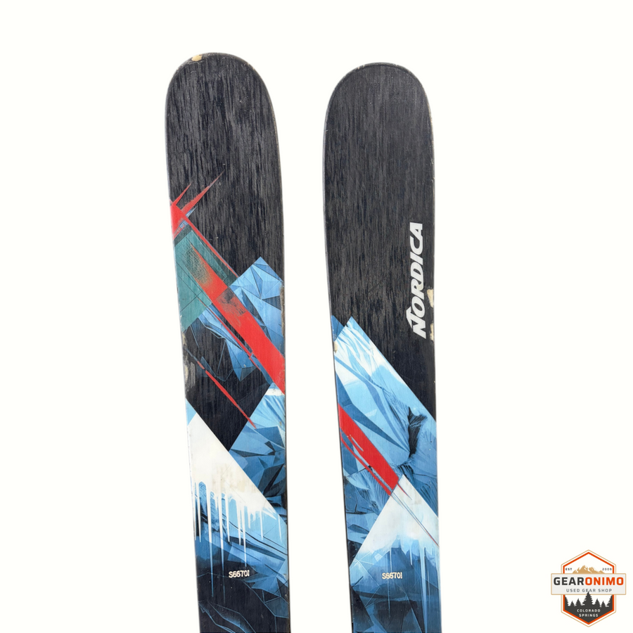 Gearonimo Sports Nordica Enforcer 99 skis with geometric blue and red mountain graphic design on a cardboard surface