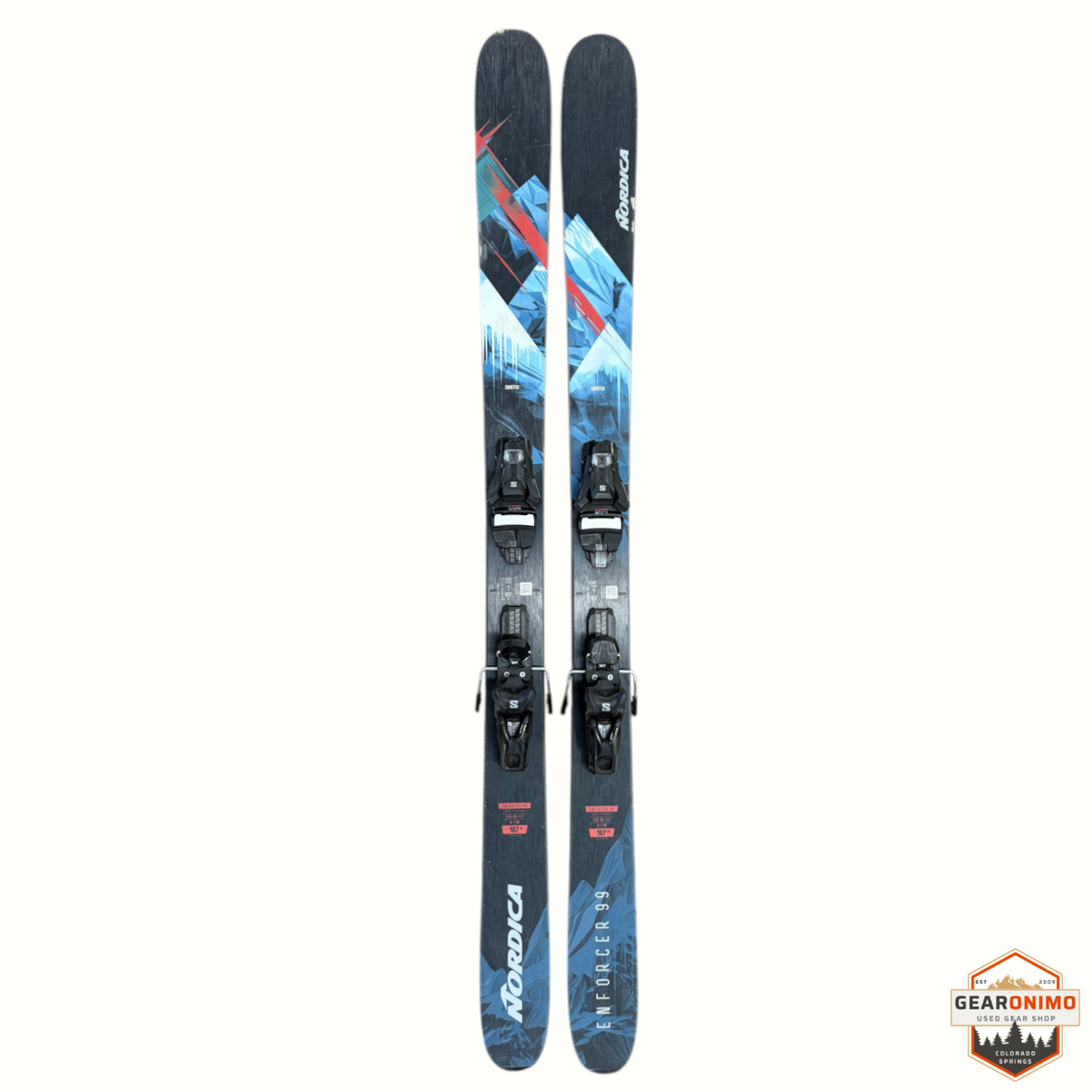 Gearonimo Sports Nordica Enforcer 99 skis with Salomon Strive 11 bindings, featuring blue and red geometric graphics.
