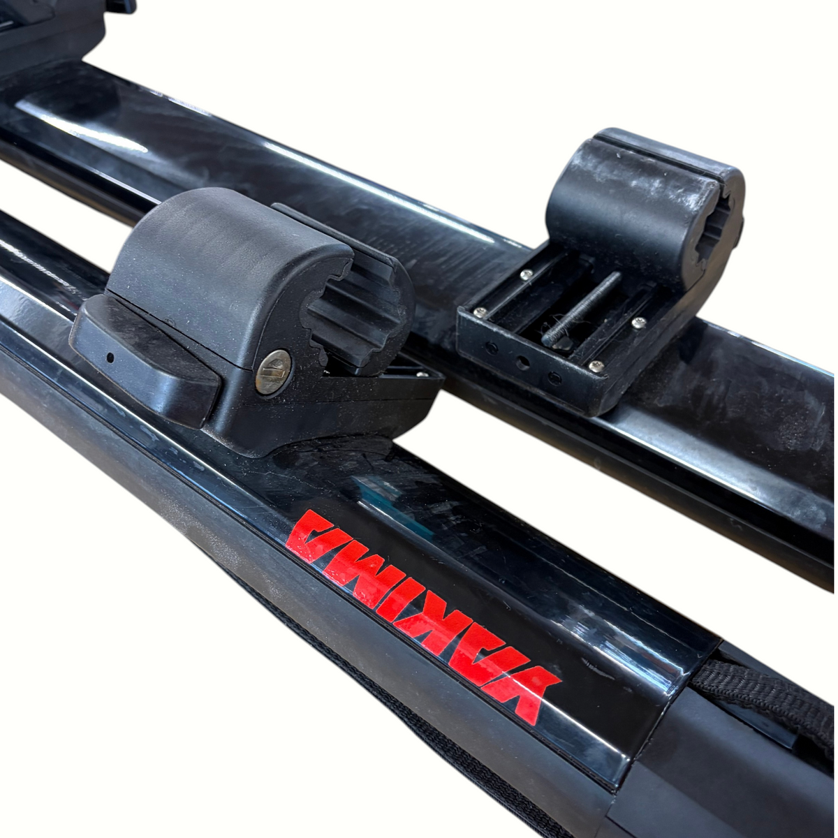 Gearonimo Sports Yakima SUP Dawg roof rack system with black locking mounts and red branding on a cardboard surface